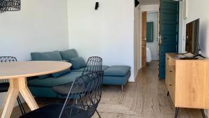 a living room with a blue couch and a table at El Gavell, Terrace Boutique Apartament in L'Escala