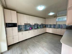 a large kitchen with white cabinets and a tile floor at ZAKAT in Zatoka