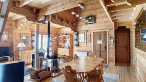 a wooden cabin with a wooden table in a room at Chalet chaleureux - 9 personnes - 3km des pistes - proche Morzine - Iaorana in Saint-Jean-d'Aulps