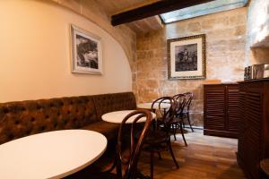 a restaurant with tables and chairs in a room at The Burrow Guest House in Tarxien