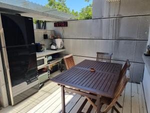 een patio met een tafel en 2 stoelen en een televisie bij וילה אברמוביץ in Rishon LeẔiyyon