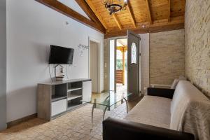 a living room with a couch and a tv at Fotini Studios in Paleokastritsa