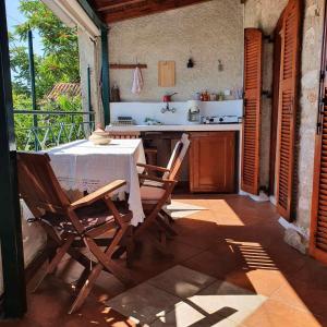 uma cozinha com uma mesa e cadeiras num pátio em Grandpa's home em Areopoli