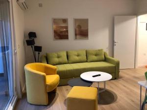 - un salon avec un canapé vert et des chaises dans l'établissement Apartment N & N, à Struga