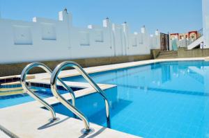 a swimming pool with blue water in a building at Lamar Azur Hotel in Dumyāţ al Jadīdah