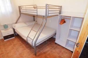 Casa rural Antich Delta del Ebro في ديلتيبري: سرير بطابقين في غرفة صغيرة مع ثلاجة
