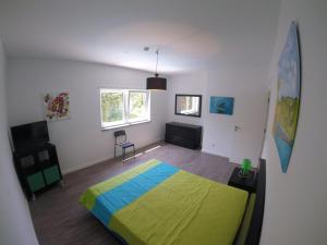 Un dormitorio con una cama verde y azul. en Casa Verde, en Feteira