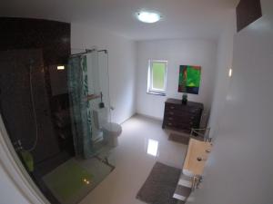 Un baño con ducha, inodoro y lavabo. en Casa Verde, en Feteira 22 fotos más