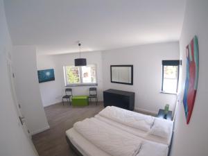 Habitación blanca con cama, mesa y sillas en Casa Verde, en Feteira