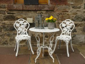 a white table with two chairs and a table with flowers at Silverstripe in Turriff