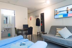 ein Wohnzimmer mit 2 Sofas und einem TV in der Unterkunft HITrental Allmend Standard Studios in Luzern