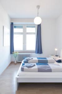 a bedroom with a large bed with blue curtains at HITrental Seefeld - Kreuzstrasse Apartments in Zurich