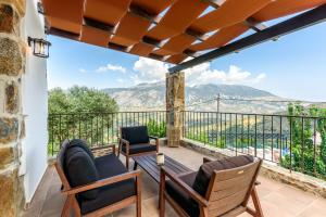 a patio with chairs and a table on a balcony at Minos Country Living Apartments in Agrilés