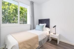 a white bedroom with a bed and a window at iloftmalaga Ricardo Soriano in Marbella