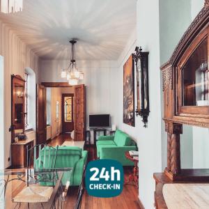 a living room with green chairs and a table at Cluj Apartments in Cluj-Napoca