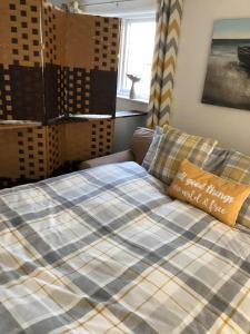 Una cama en una habitación con una manta. en SunKist Lodge en Bridlington