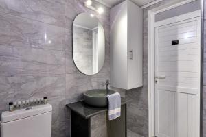 a bathroom with a sink and a mirror and a toilet at Fotini Studios in Paleokastritsa