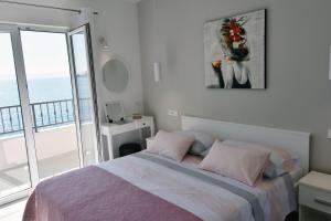 Villa NEDE 2 في بودغورا: غرفة نوم مع سرير وإطلالة على المحيط