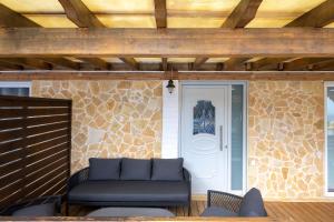 a porch with a couch in front of a door at Fotini Studios in Paleokastritsa