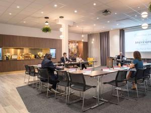 a group of people sitting at tables in a meeting room at Mercure Paris Porte de Pantin in Pantin