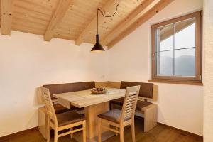 Un comedor con mesa y sillas de madera. en Unterötzbauerhof - Fewo Rosenblick, en Tirolo