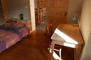 1 dormitorio con escritorio, 1 cama y 1 mesa en Joli appartement confortable rénové style cosy, en Saint-Martin-de-la-Porte