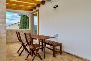 a wooden table and chairs on a porch with a window at Fotini Studios in Paleokastritsa