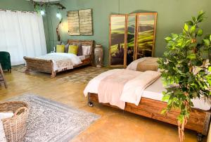 a bedroom with two beds and a potted plant at Lush in Graskop