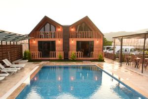 a house with a swimming pool in front of a house at İRBEÇ APART & BUNGALOW in Demre