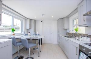 a white kitchen with a table and chairs in it at Station 36 in Portstewart