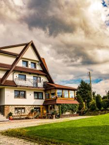 a house with a green lawn in front of it at Dom Gościnny WYBRANIEC in Poronin