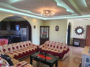 a living room with two couches and a table at Mihal Suites in Sarandë