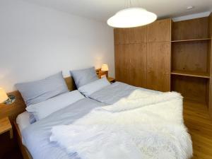 um quarto com uma cama grande e lençóis brancos em Landhaus Renata - Wendelstein em Bayrischzell