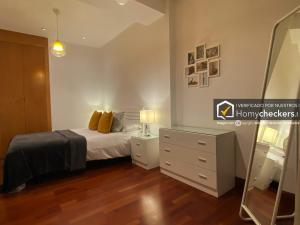 a bedroom with a bed and a dresser and a mirror at HomyAT Prior Romo, Plaza Mayor in Salamanca