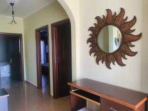 a mirror on the wall of a room with a table at Mihal Suites in Sarandë