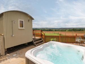 a hot tub on a patio next to a building at Shepherds Hut in Rugeley