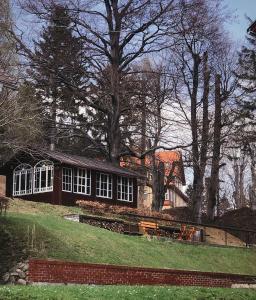 a house on a hill with trees and grass at Willa Dąbrówka in Karpacz