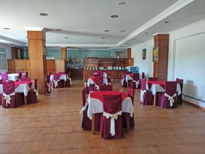 サンシェンショにあるHotel Galaico Sanxenxoの赤と白のテーブルと椅子が備わる宴会場