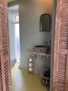 een badkamer met een wastafel en een spiegel aan een muur bij So Hum in Den Burg