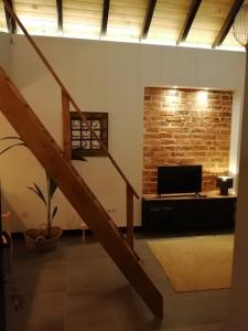 a staircase in a room with a television and a brick wall at Villa Vista in Sesimbra