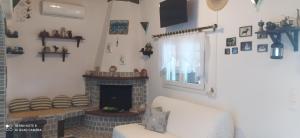 a living room with a fireplace and a white couch at Ekali-Haus in Nea Iraklia