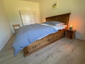 een slaapkamer met een groot bed met een houten hoofdeinde bij Landhaus Viezer Mühle in Viez