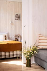 1 dormitorio con 1 cama y un jarrón de flores en ZATORHOUSE, en Zator