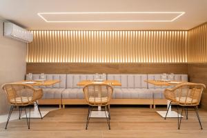 a restaurant with three tables and a white couch at Halley Hotel & Apartments Affiliated by Meliá in Benidorm