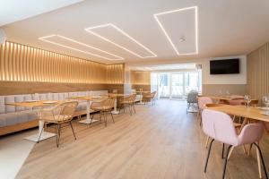 a restaurant with tables and chairs and a couch at Halley Hotel & Apartments Affiliated by Meliá in Benidorm