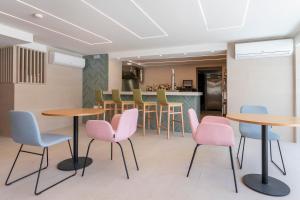 a waiting room with pink and blue chairs and tables at Halley Hotel & Apartments Affiliated by Meliá in Benidorm