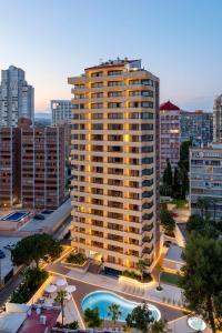 a tall building with a pool in a city at Halley Hotel & Apartments Affiliated by Meliá in Benidorm