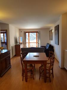 a living room with a table and a couch at Soldeu Paradis Pleta in Soldeu