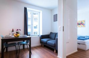 ein Wohnzimmer mit einem Tisch und einem Sofa in der Unterkunft HITrental Altstetten Apartments in Zürich