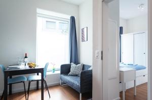 a living room with a table and a chair at HITrental Altstetten Apartments in Zürich